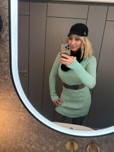 Selbstporträt von Joelle Monroe, mit grünem Oberteil und Hut.